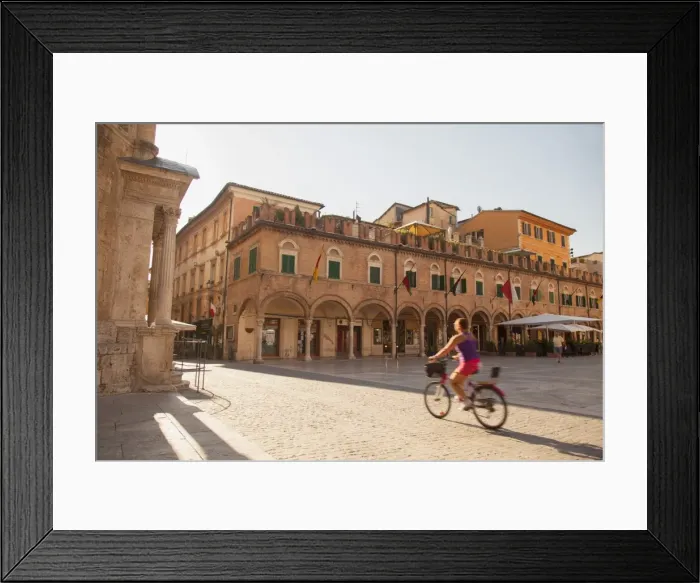 Framed Print : Woman cycling through Piazza del Popolo, Ascoli Piceno, Le Marche, Italy Framed Print : Woman cycling through Piazza del Popolo, Ascoli Piceno, Le Marche, Italy