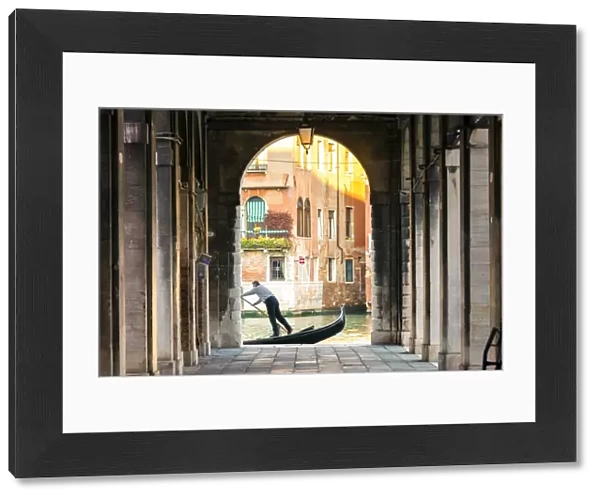Italy, Veneto, Venice. Gondola passing on Grand canal seen from a colonnade