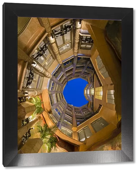 Bottom view of the inner courtyard of Casa Mila or La Pedrera at dusk, Barcelona