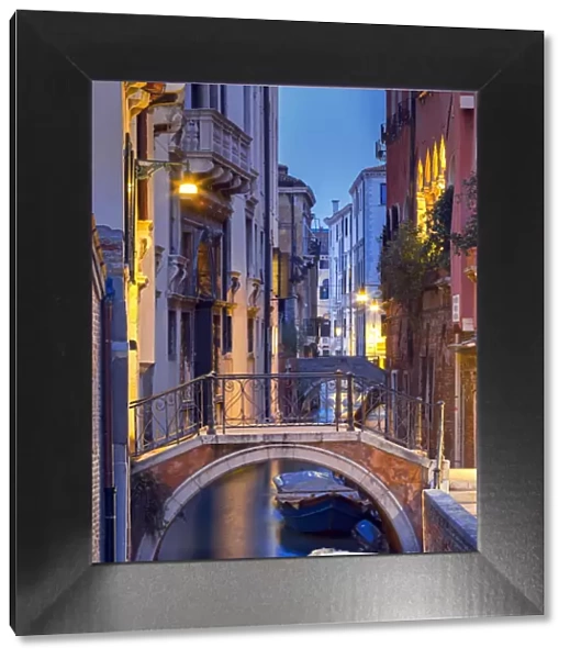 Venice, Veneto, Italy. View over a bridge and a canal at dusk
