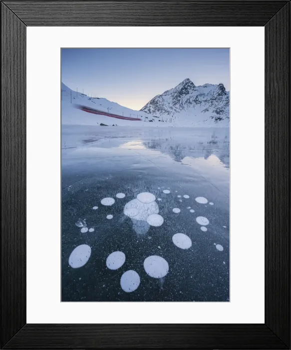 Framed Print : The Bernina Express train runs along the frozen Lake Bianco, Bernina Pass with some bubbles Framed Print : The Bernina Express train runs along the frozen Lake Bianco, Bernina Pass with some bubbles