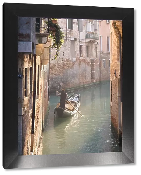 Gondola and gondolier in a small venetian canal, Venice, Veneto, Italy