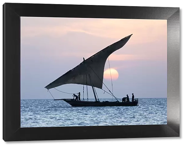 A dhow sails in front of the setting sun, Stone Tpwn, Zanzibar, Tanzania
