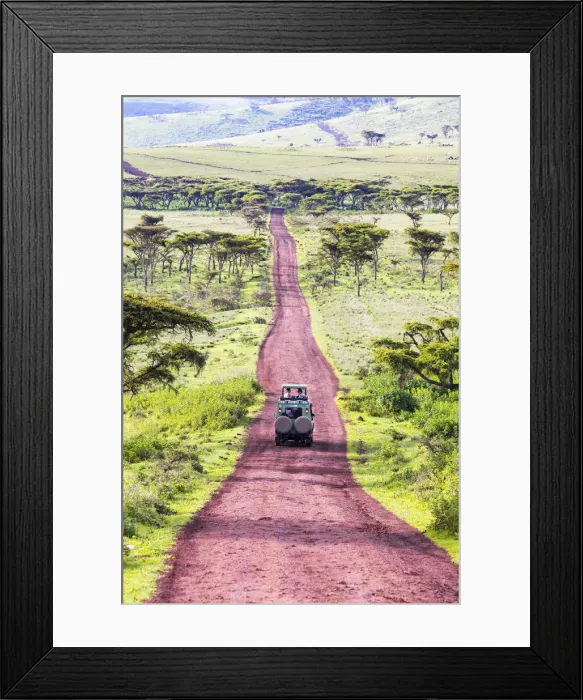 Framed Print : A 4-wheel drive safari vehicle drives along a red track near the Ngorongoro Crater Framed Print : A 4-wheel drive safari vehicle drives along a red track near the Ngorongoro Crater