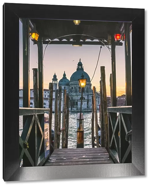 Venice, Veneto, Italy. Salute (St Mary of Health) Basilica and wooder pier at dusk