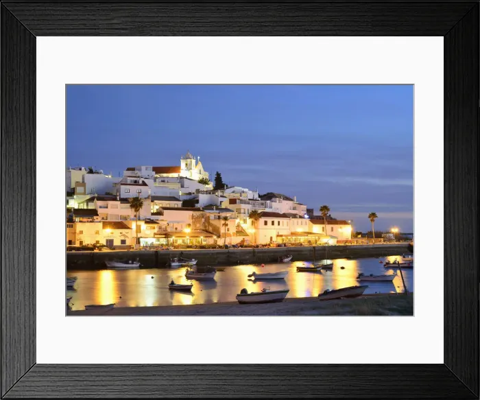 Framed Print : The traditional fishing village of Ferragudo at dusk, bordering the Arade river. Algarve