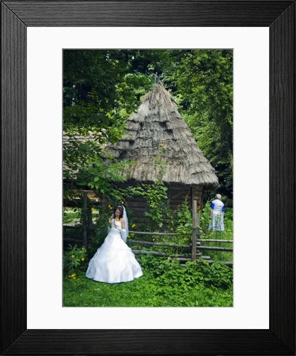 Framed Print : Bride stood in front of a traditional thatched roof Framed Print : Bride stood in front of a traditional thatched roof