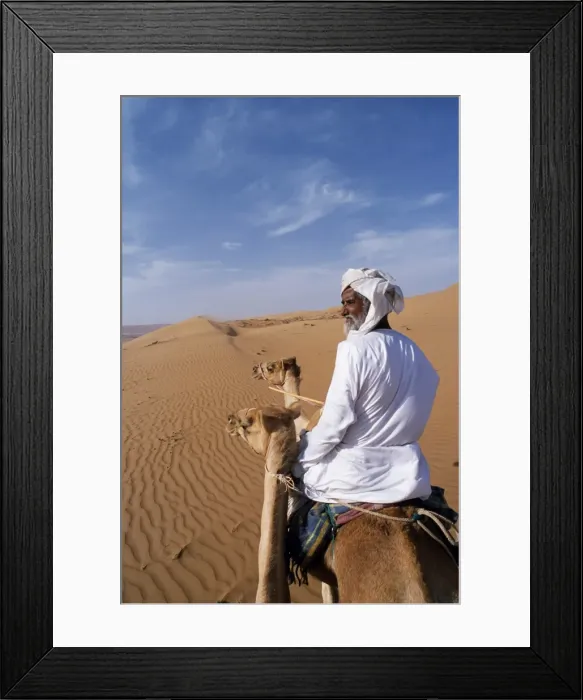 Framed Print : A Bedu rides his camel in the desert Framed Print : A Bedu rides his camel in the desert