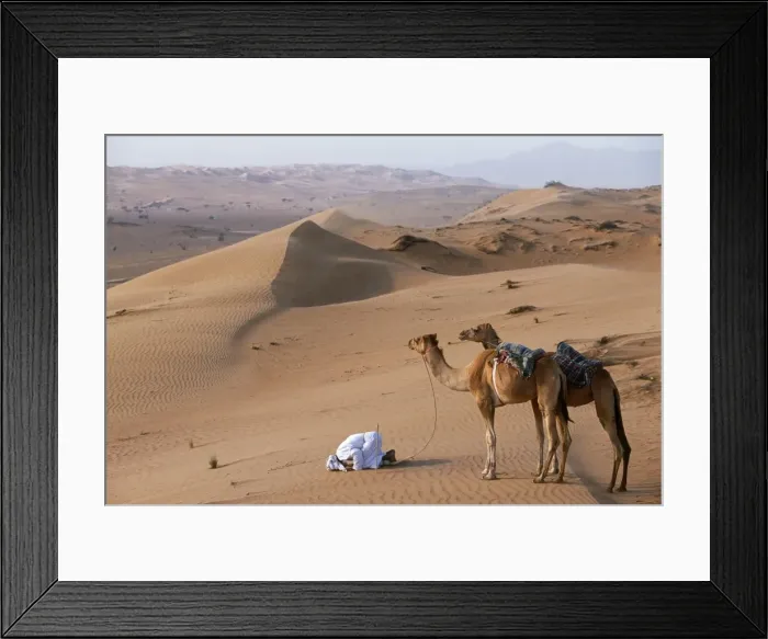 Framed Print : A Bedu kneels to pray in the desert Framed Print : A Bedu kneels to pray in the desert