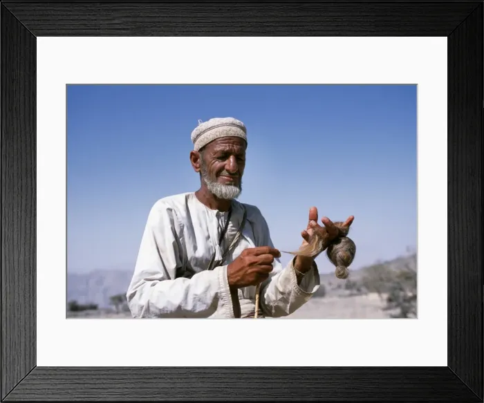 Framed Print : An old goatherd spins wool at his village on the rim Framed Print : An old goatherd spins wool at his village on the rim