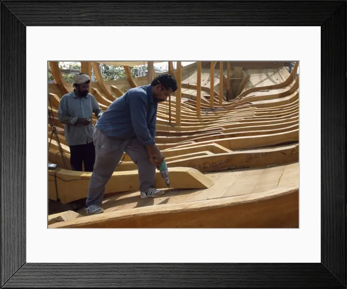 Framed Print : Boat builders constructing a large dhow in the boat yard at Sur Framed Print : Boat builders constructing a large dhow in the boat yard at Sur