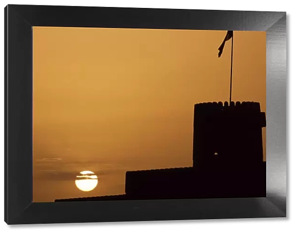 Silhouette of one of the towers of Ras al Hadd Castle at sunset