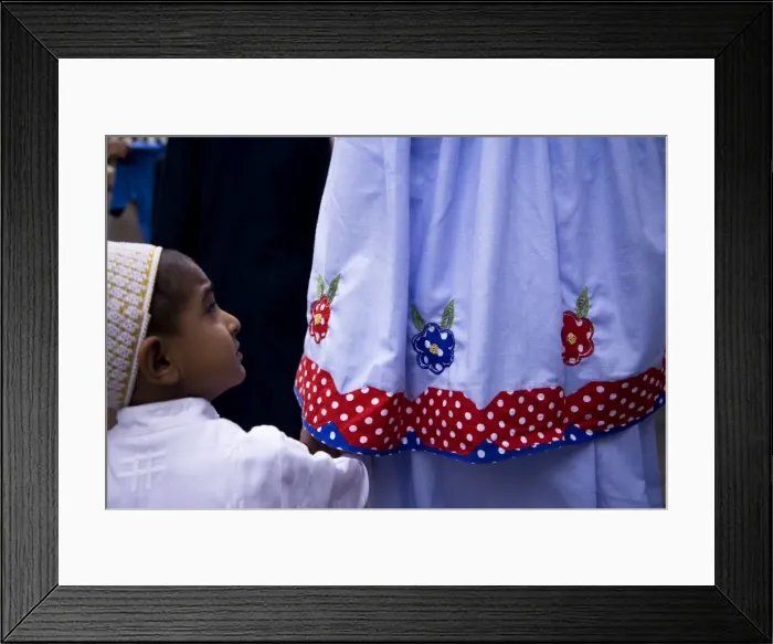 Framed Print : A boy follows his mother through the crowds outside