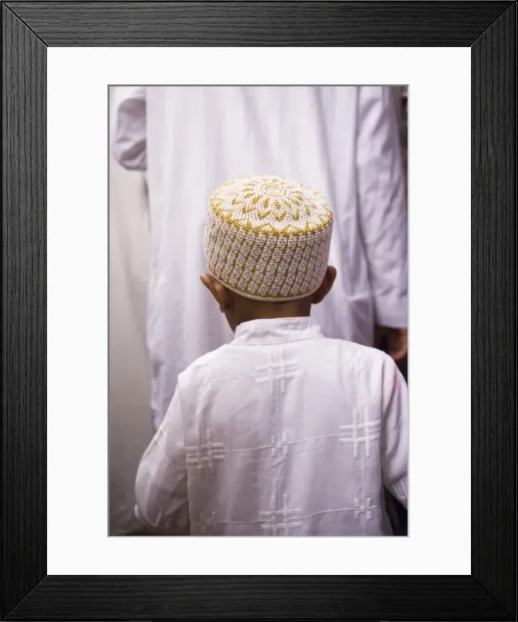Framed Print : A boy follows his father through the crowds outside Framed Print : A boy follows his father through the crowds outside