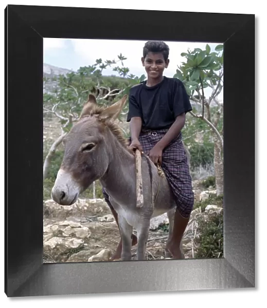 A boy rides home after school on a donkey in the Homhil Mountains