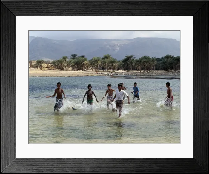 Framed Print : Children enjoy a boat race in a lagoon at Qalansiah Framed Print : Children enjoy a boat race in a lagoon at Qalansiah