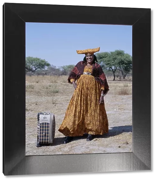 A smartly dressed Herero woman waits for a bus