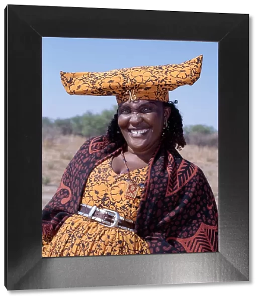 A smartly dressed Herero woman has a beaded AIDS badge