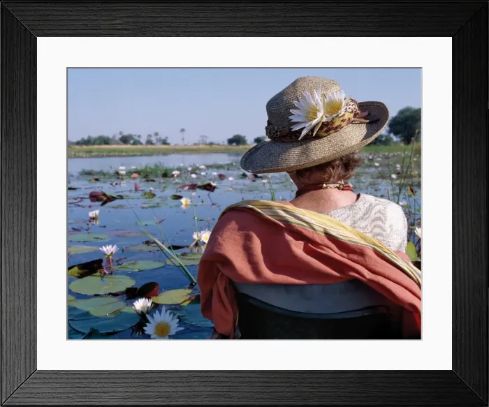 Framed Print : A boatman in his mokoro dug-out canoe takes a tourist Framed Print : A boatman in his mokoro dug-out canoe takes a tourist