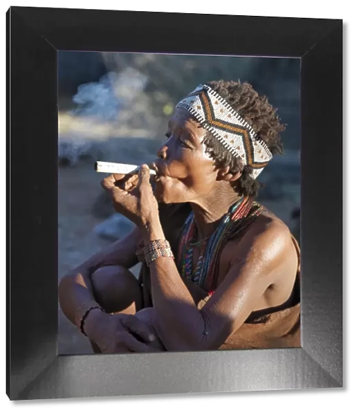 A woman from the N!!S hunter-gatherer band enjoys a smoke