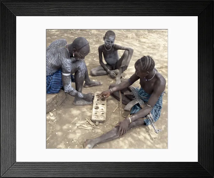 Framed Print : Two Mursi men with singular hairstyles play a game Framed Print : Two Mursi men with singular hairstyles play a game