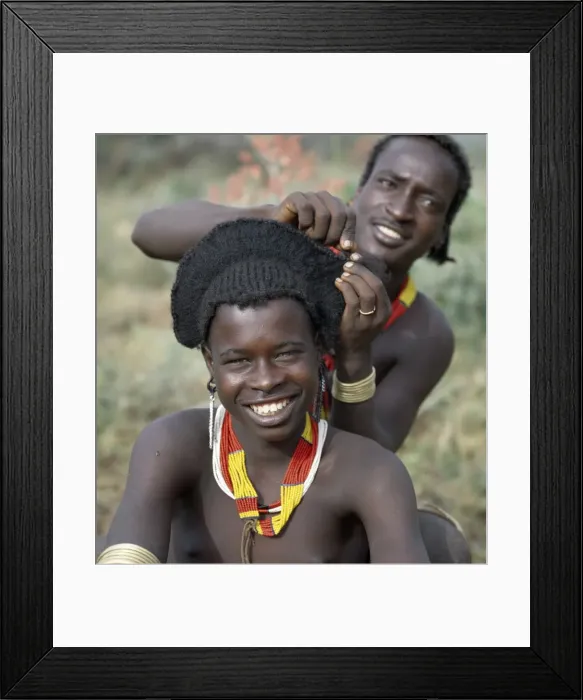 Framed Print : An elaborate hairstyle of a young Hamar man nears completion Framed Print : An elaborate hairstyle of a young Hamar man nears completion