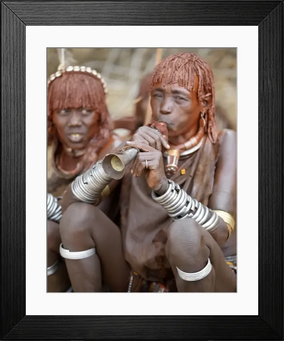 Framed Print : A Hamar woman blows a tin trumpet at a Jumping Framed Print : A Hamar woman blows a tin trumpet at a Jumping