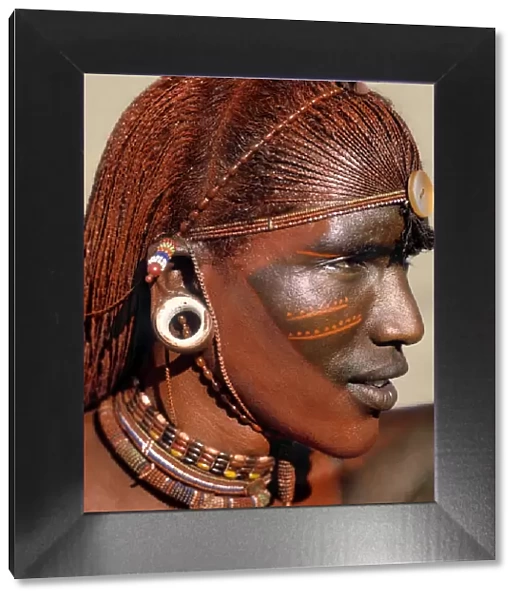 A Samburu warrior resplendent with long, braided, Ochred hair