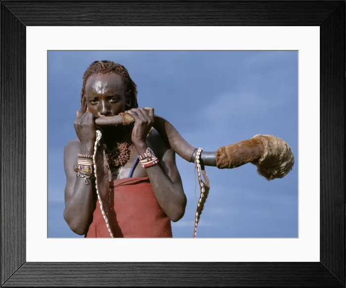 Framed Print : A Msai warrior blows a trumpet fashioned from Framed Print : A Msai warrior blows a trumpet fashioned from