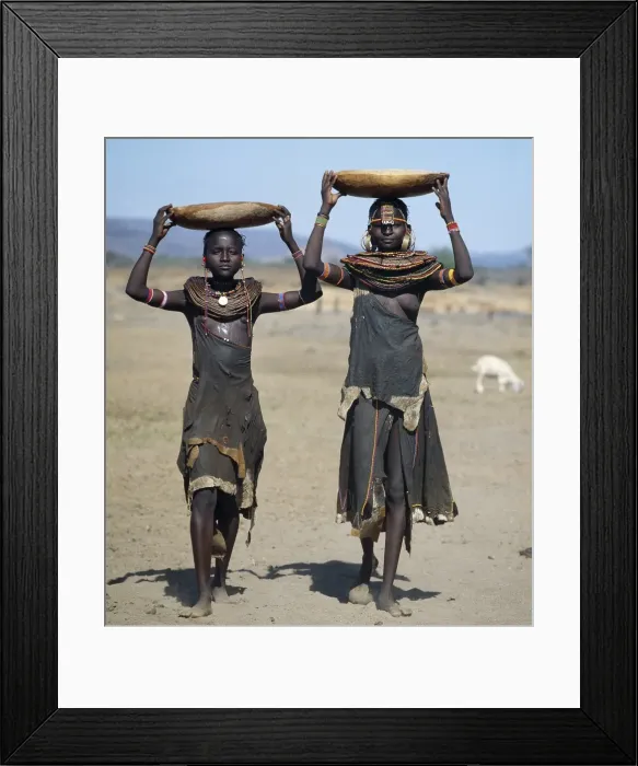 Framed Print : Two Pokot girls carry water in wooden containers on their heads Framed Print : Two Pokot girls carry water in wooden containers on their heads