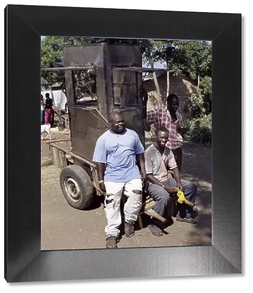An unfinished mobile phone kiosk is carried on a mkokoteni