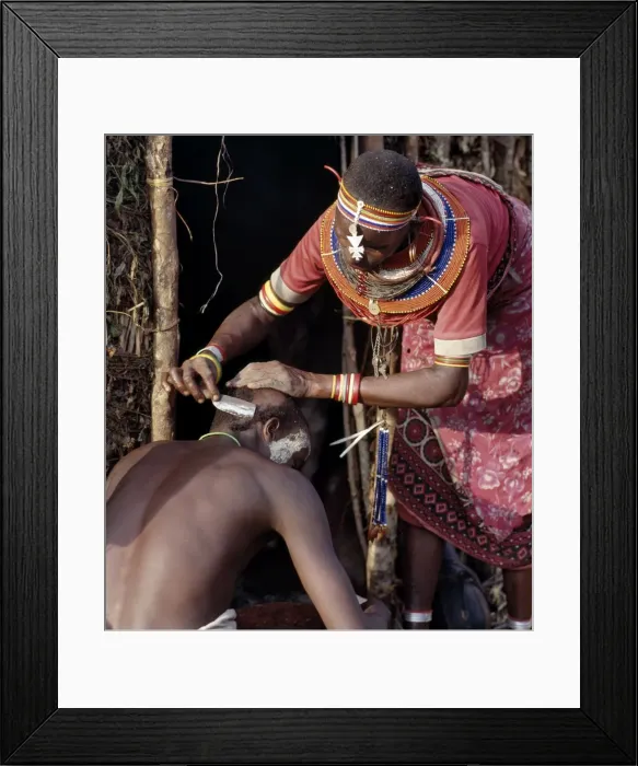 Framed Print : A Samburu mother shaves her sons head outside Framed Print : A Samburu mother shaves her sons head outside