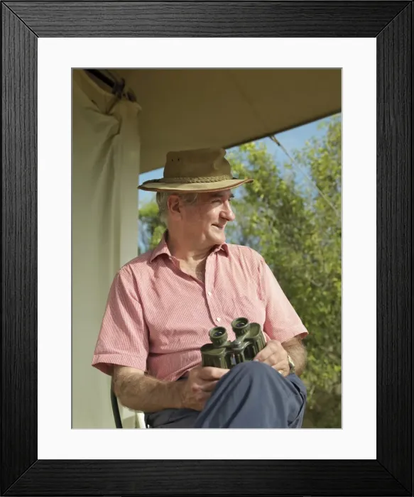 Framed Print : A tourist watches birds and animals from the verandah