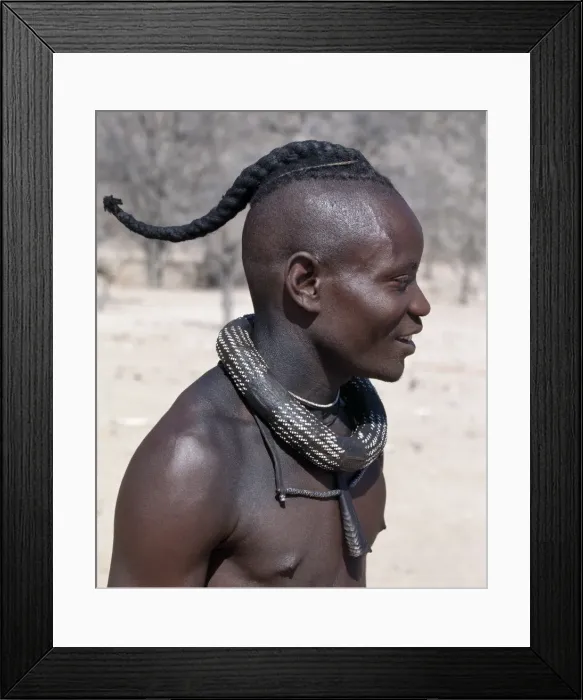 Framed Print : A Himba youth has his hair styled in a long plait, known as ondatu Framed Print : A Himba youth has his hair styled in a long plait, known as ondatu