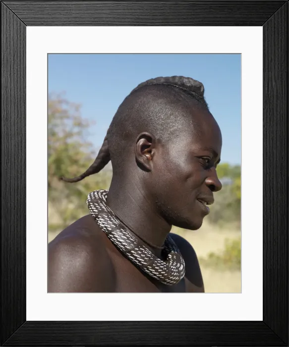 Framed Print : A Himba youth with his hair styled in a long plait, known as ondatu