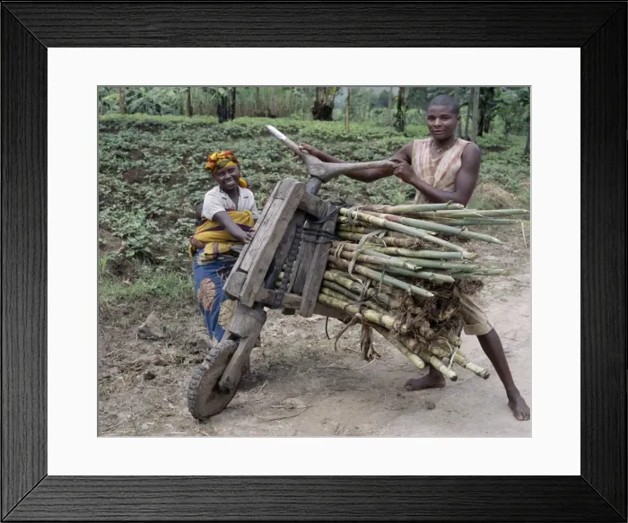 Framed Print : A young man and his wife push a homemade wooden bicycle Framed Print : A young man and his wife push a homemade wooden bicycle