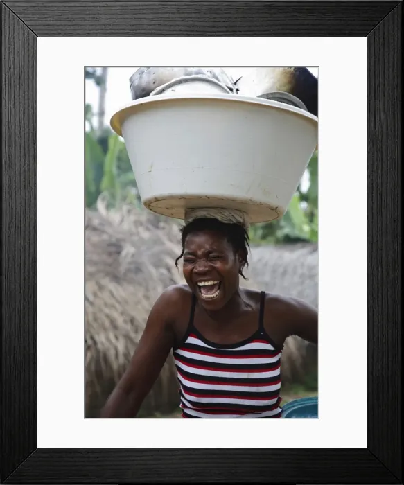 Framed Print : A Sao Tomense woman laughs while carrying her washing up on her head Framed Print : A Sao Tomense woman laughs while carrying her washing up on her head