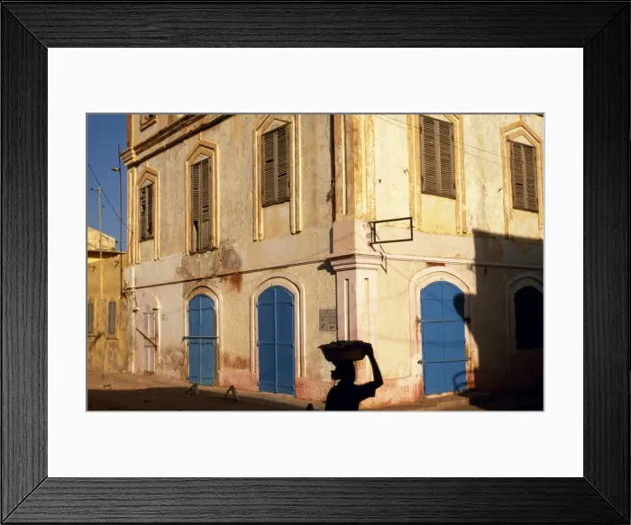 Framed Print : A woman walks along a St Framed Print : A woman walks along a St