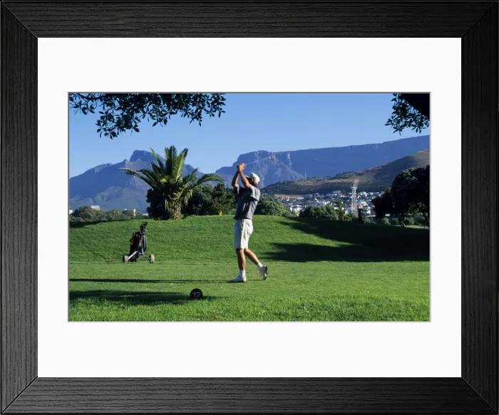 Framed Print : A player tees off at the golf course at Green Point overlooked by Table Mountain Framed Print : A player tees off at the golf course at Green Point overlooked by Table Mountain