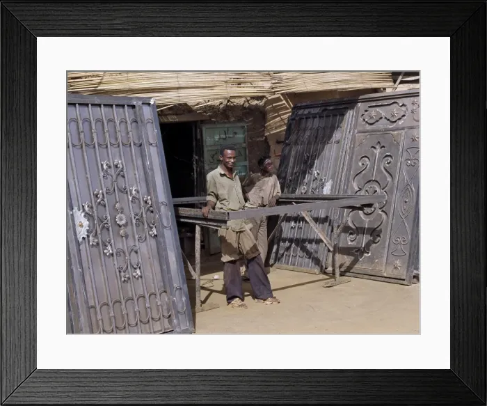 Framed Print : Skilled craftsmen pause beside two pairs of elaborately Framed Print : Skilled craftsmen pause beside two pairs of elaborately