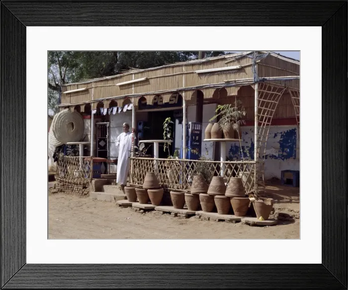 Framed Print : The owner of a roadside shop waits for customers on Framed Print : The owner of a roadside shop waits for customers on