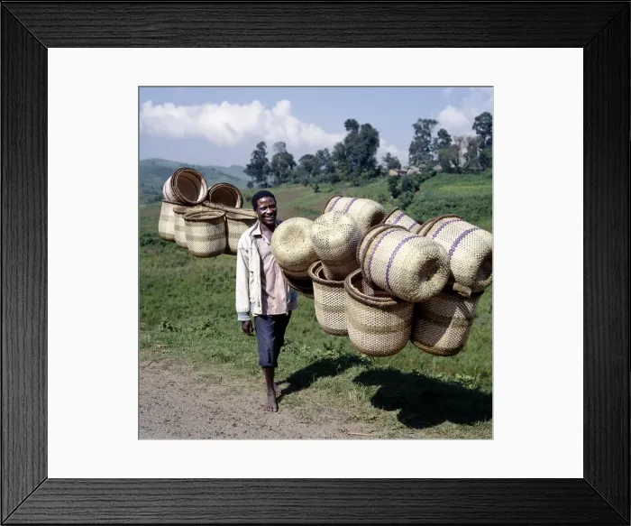 Framed Print : A man carries traditional split-bamboo baskets to sell Framed Print : A man carries traditional split-bamboo baskets to sell