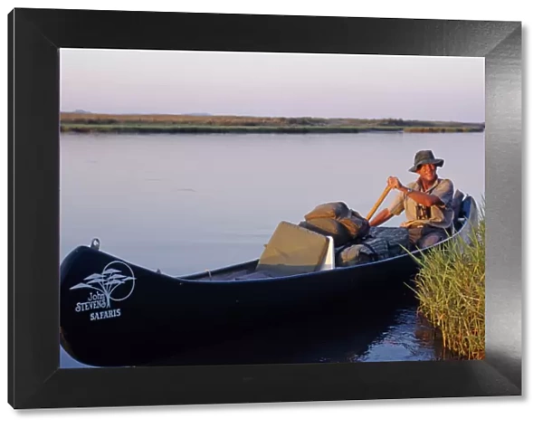 John Stevens paddling his canoe on the Zambezi at sunset
