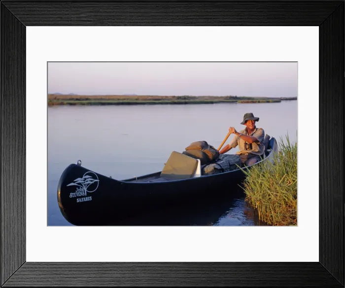 Framed Print : John Stevens paddling his canoe on the Zambezi at sunset