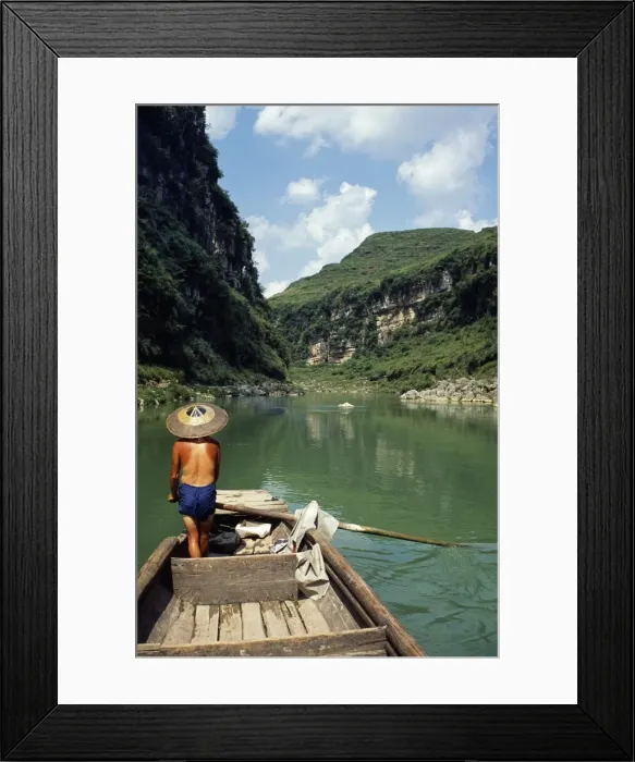 Framed Print : A boatman rows between the hills and cliffs of the Chong an River Framed Print : A boatman rows between the hills and cliffs of the Chong an River
