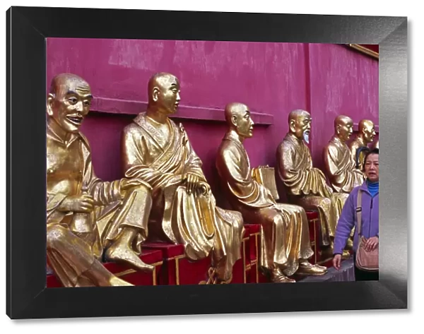A row of golden Buddha statues greets visitors to the