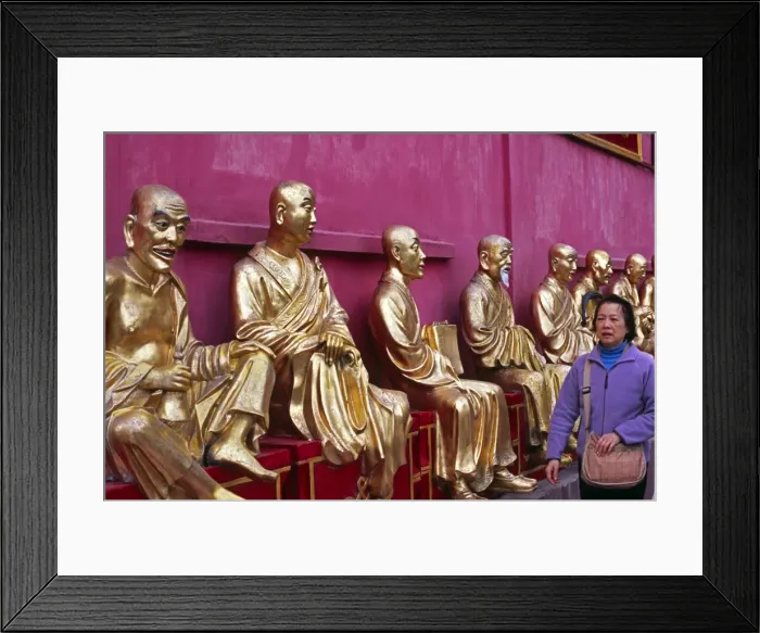 Framed Print : A row of golden Buddha statues greets visitors to Framed Print : A row of golden Buddha statues greets visitors to
