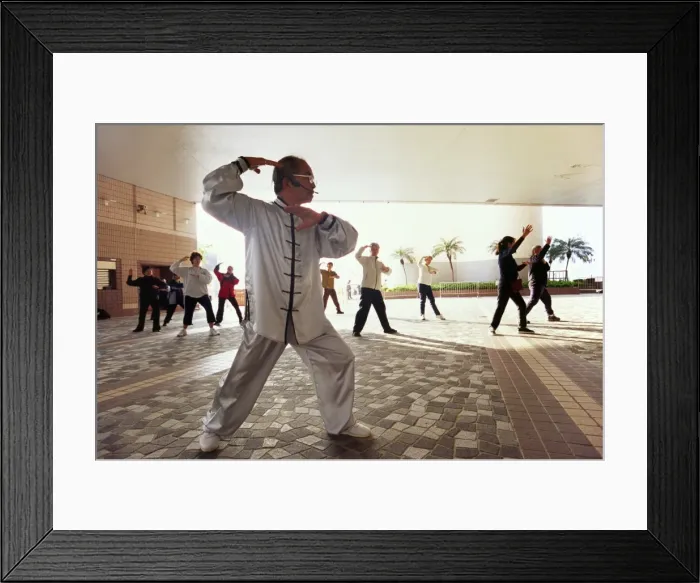 Framed Print : A group perform T ai chi near the Kowloon waterfront