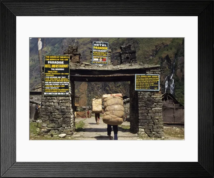 Framed Print : Heavily laden porters enter village gateway Framed Print : Heavily laden porters enter village gateway