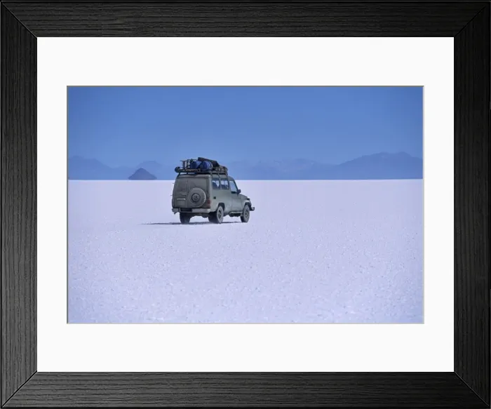Framed Print : A vehicle drives across the crusted salt of the Salar de Uyuni Framed Print : A vehicle drives across the crusted salt of the Salar de Uyuni